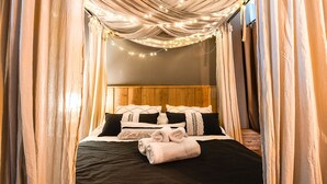 A bed with a wooden headboard, black and white bedding, and a rolled towel. - Montaña apartment with lake view and parking in Bariloche (San Carlos de Bariloche)