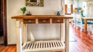 A wooden desk with drawers and a shelf, placed in a room with wooden flooring and white walls. - Namaste apartment with pool and recreational area in Bariloche (San Carlos de Bariloche)