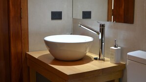 A bathroom with a wooden vanity, a white sink, a mirror, and a toilet. - Suizo II Romantic apartment with Nahuel Huapi Lake (San Carlos de Bariloche)