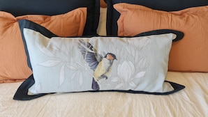 A bed with a pillow featuring a bird design. - Swiss IV apartment with an impressive lake view Nahuel Huapi (San Carlos de Bariloche)