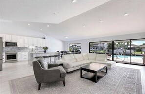 Relax in a spacious living area with a large L-shaped sofa and central island kitchen.