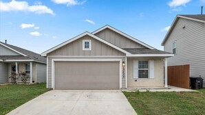 A single-story house with a garage, a small porch, and a well-maintained lawn. - Incredible Stay Fast Wifi Fully Equipped (San Antonio)