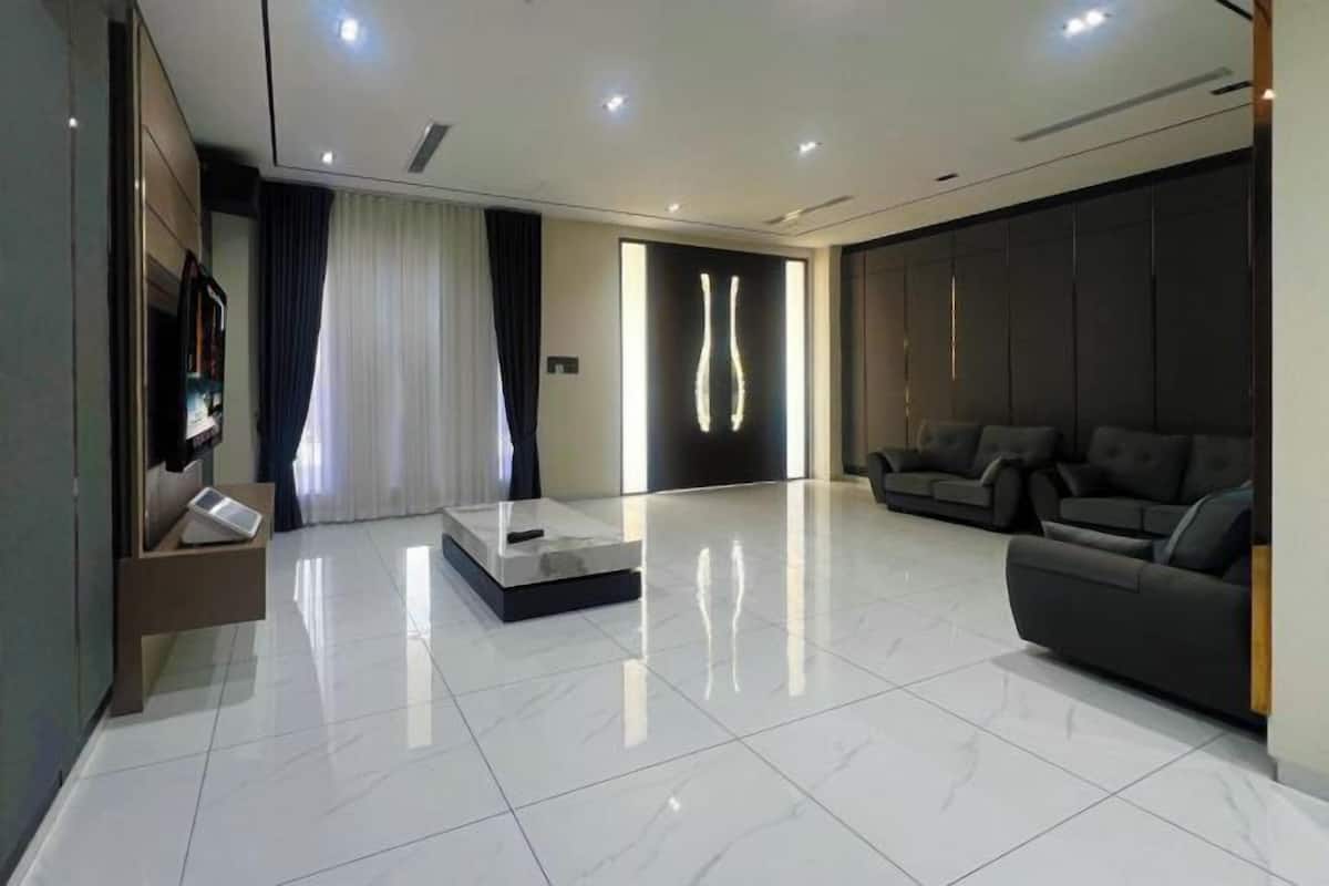 A modern living room with a sofa, a coffee table, and a TV.