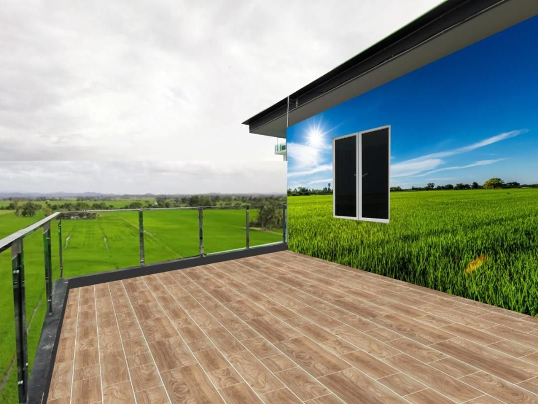 A balcony with a view of a green field and a clear sky.