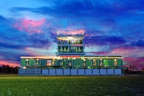 A multi-story hotel with a central tower and a flat-roofed structure. - Villa Chee (Sekinchan)