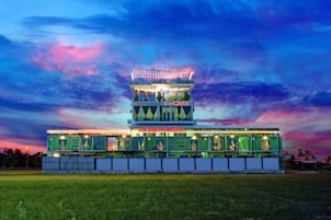A multi-story hotel with a central tower and a flat-roofed structure.