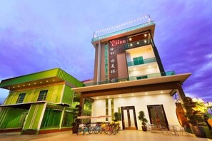 A hotel with a prominent sign, multiple floors, and a balcony. - Villa Chee (Sekinchan)