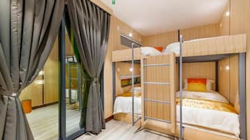 A bunk bed room with a sliding door and a small table.