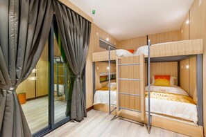 A bunk bed room with a sliding door and a small table. - Villa Chee (Sekinchan)