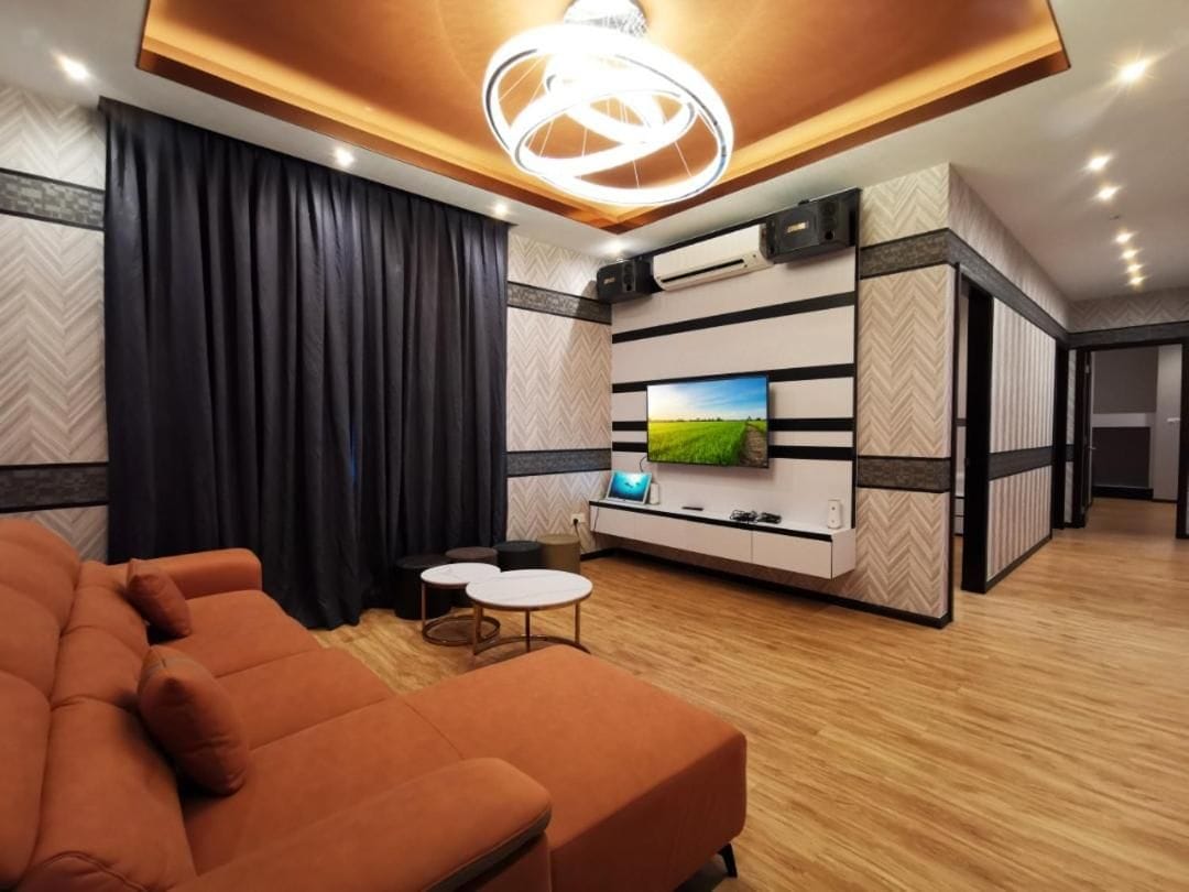 A modern living room with a sofa, a flat-screen TV, and a decorative ceiling light.