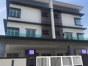 A multi-story residential building with balconies, a gated entrance, and a flat roof. - Villa Chee (Sekinchan)
