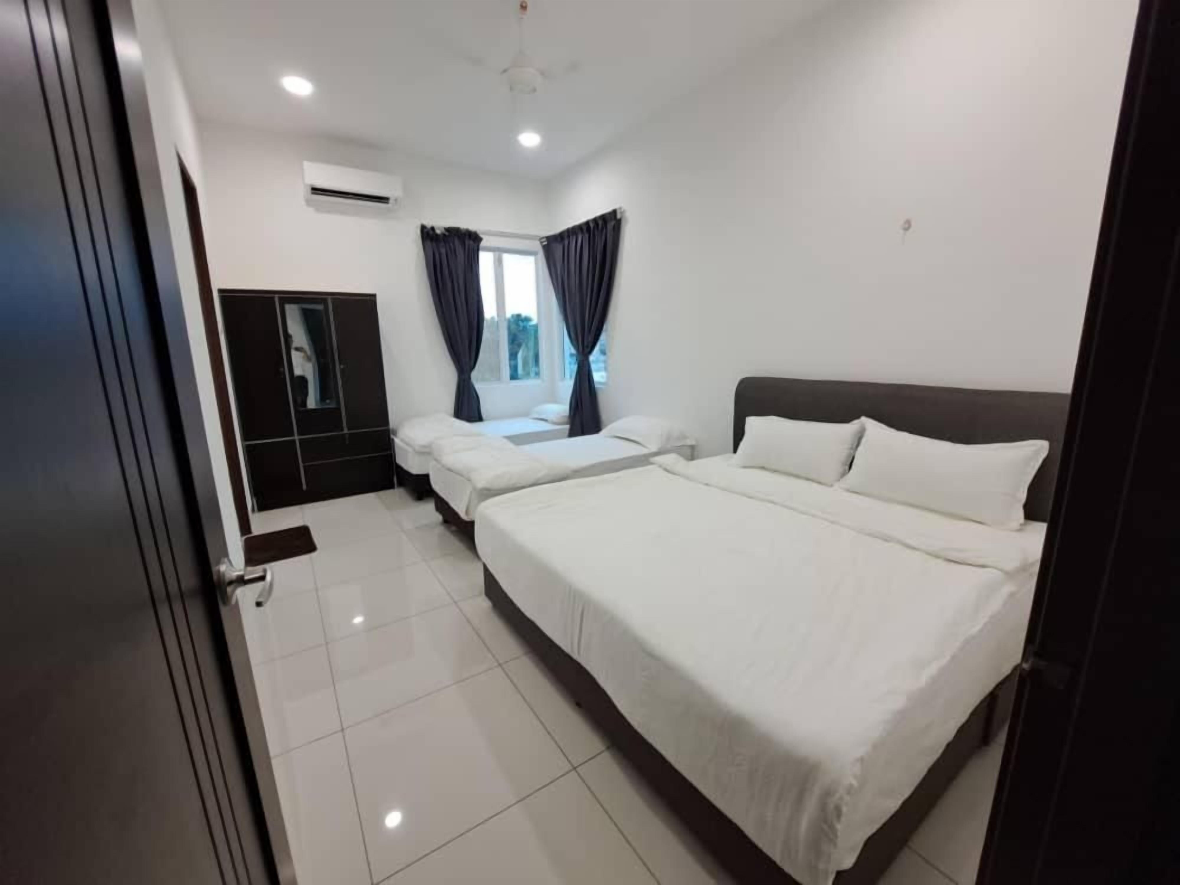 A hotel room with a large bed, a wardrobe, and a window with curtains.