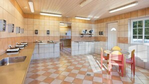Eine moderne Küche mit Schachbrettböden, Holzschränken und einer zentralen Kochinsel mit Spüle.