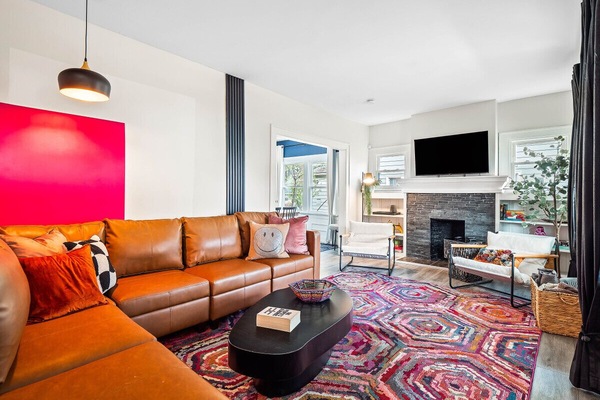 A vibrant living room, bursting with personality! 🧡 The pops of color and comfy seating make this space feel inviting. #CozyVibes