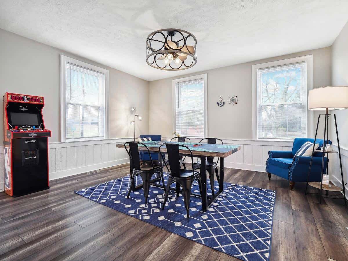 A dining area with a table and chairs, a ceiling fan, and a jukebox.