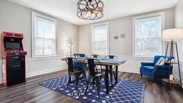 A dining area with a table and chairs, a ceiling fan, and a jukebox.