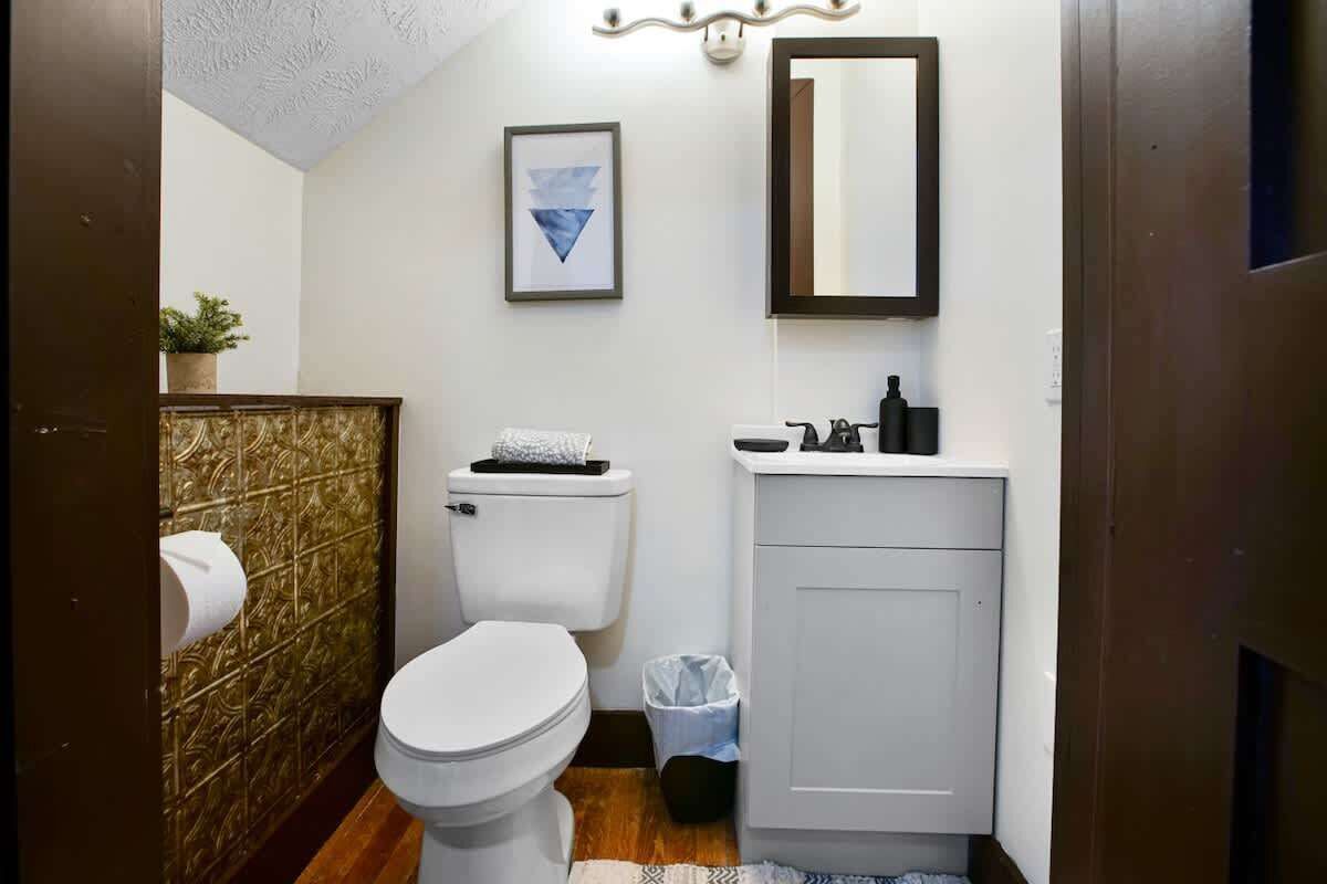 Ein kleines Badezimmer mit Toilette, Waschbecken und Spiegel.