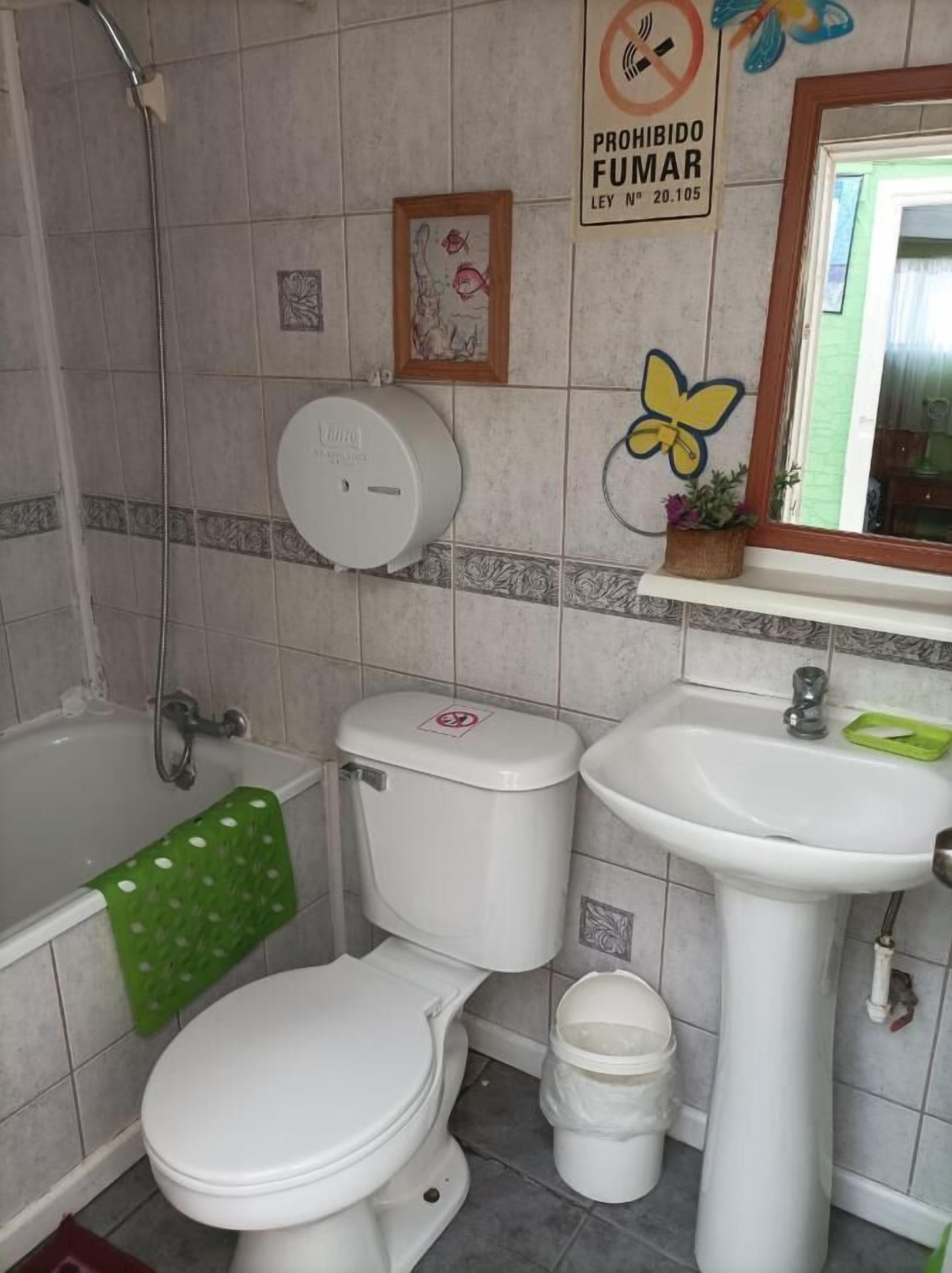 A bathroom with a toilet, sink, and bathtub.