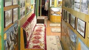 A narrow hallway with a bench, framed pictures on the walls, and a small table with a mirror.