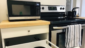 Una cocina equipada con microondas, estufa y horno.