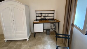 A compact kitchen with a sink, a small cabinet, and a chair. - HOUSE CENTER CASTRIGNANO 3 (CASTRIGNANO DEL CAPO)