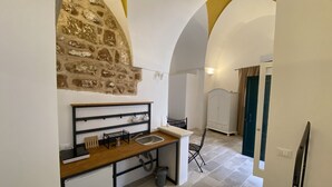 A compact kitchen with a stone wall, a wooden countertop, and a small sink. - HOUSE CENTER CASTRIGNANO 2 (CASTRIGNANO DEL CAPO)