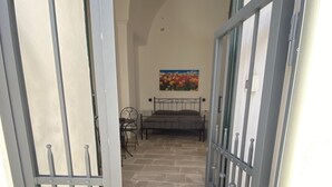 A narrow hallway with a bed and a painting on the wall. - HOUSE CENTER CASTRIGNANO 2 (CASTRIGNANO DEL CAPO)