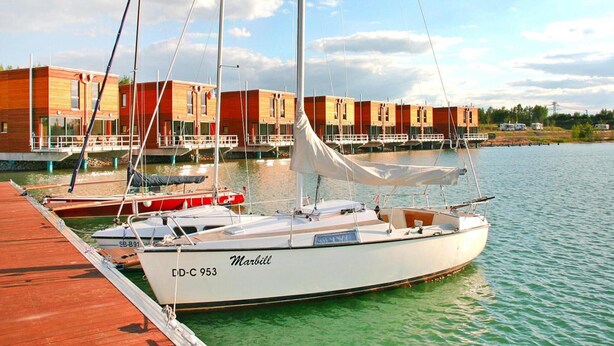 A marina with a white sailboat named 'Marbill' docked at the pier. - Luxuriose Ferienwohnung am Stormthaler See (Grossposna)