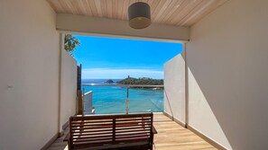 Enjoy the breathtaking sea views from this balcony with a comfortable bench and glass railing.