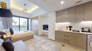 Een modern appartement met een woonruimte, kitchenette en een balkon met uitzicht op de stad.