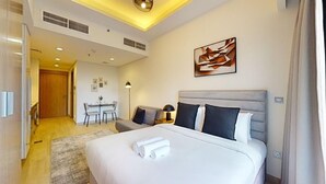 Een hotelkamer met een groot bed, een bureau en een stoel.