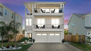 A two-story house with a garage, a balcony with chairs, and a well-maintained garden. - The Golden Palms at St. Augustine Beach (Saint Augustine Beach)