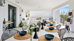 A modern, well-lit dining area with wicker chairs, round tables, and blue bowls. - Awesome home in Vodice (Vodice)