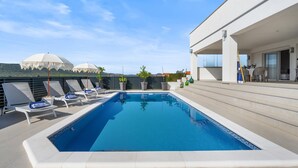 A rooftop pool with lounge chairs, a covered seating area, and a view of domed buildings in the background. - Awesome home in Vodice (Vodice)