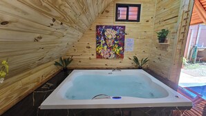 Una cabaña de madera con jacuzzi, paredes de madera y un cuadro.