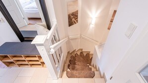 A staircase with a wooden handrail and a carpeted landing. - House Nordmarkgarten, Whg. 02a - House Nordmarkgarten (Sylt)