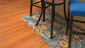 A dining area with a round table, blue upholstered chairs, a green cabinet, and a floral-patterned rug. - Vibrant Furnished Studio, Walk to LSUNO, 30+ Day Stays (New Orleans)