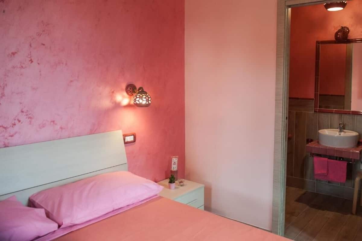 Ein Schlafzimmer mit einem Bett, einem Nachttisch und einer Wandleuchte.