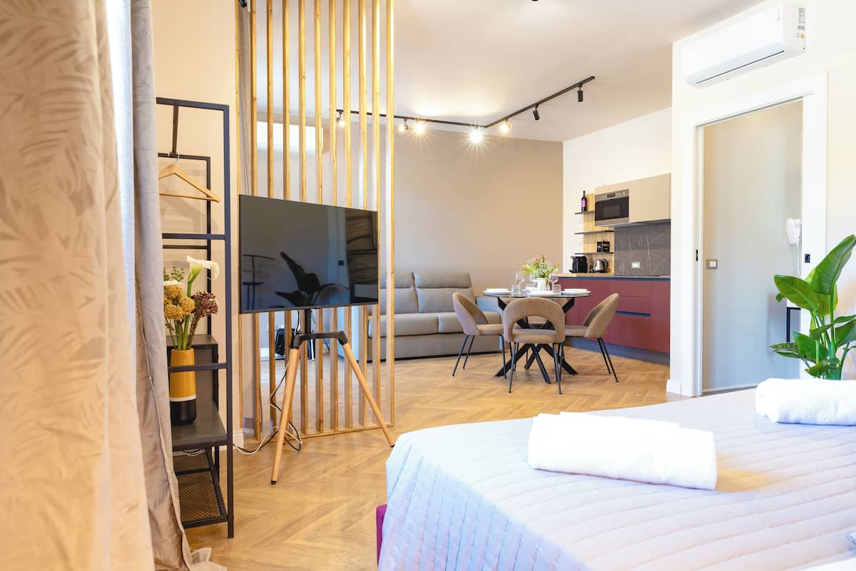 Ein modernes Hotelzimmer mit Bett, Schreibtisch, einer Couch und einem Essbereich.