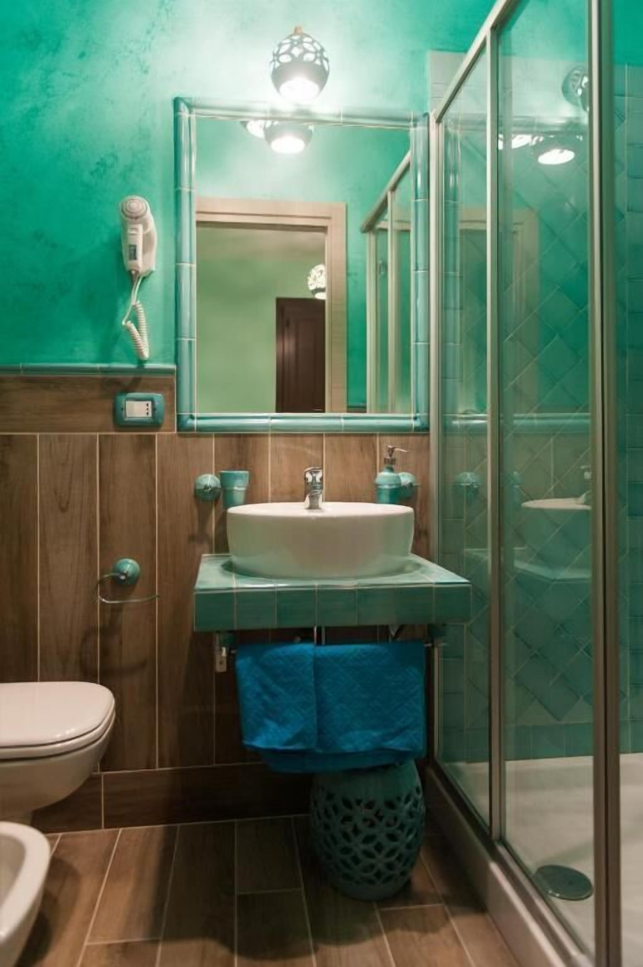 A bathroom with a white sink, a mirror, and a glass shower enclosure.
