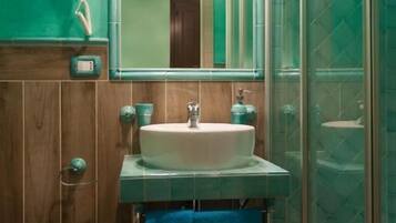 A bathroom with a white sink, a mirror, and a glass shower enclosure.