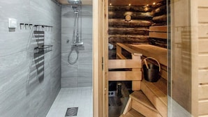 Een moderne badkamer met een douche, een houten sauna en een betegelde vloer.