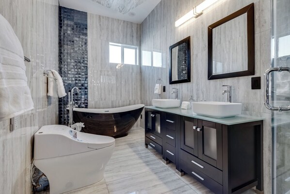 A modern bathroom with a freestanding bathtub, a double sink vanity, and a large mirror. - Spacious Modern Villa in fantastic Las Vegas with steam room+fire pit+pool+spa (Las Vegas)