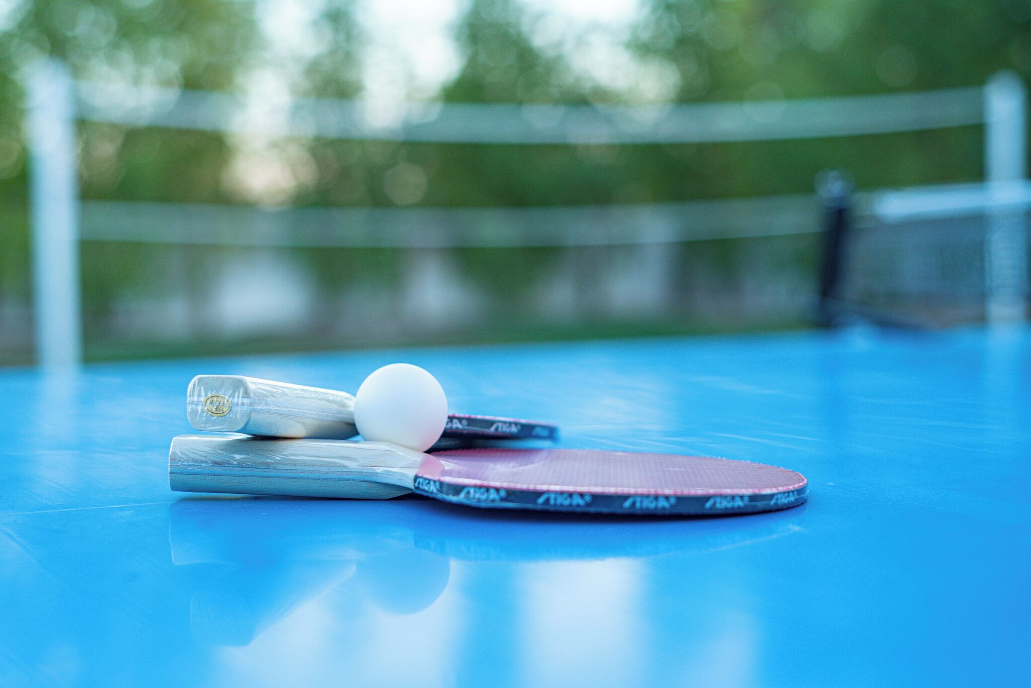 Een tafeltennistafel met een bal en rackets.