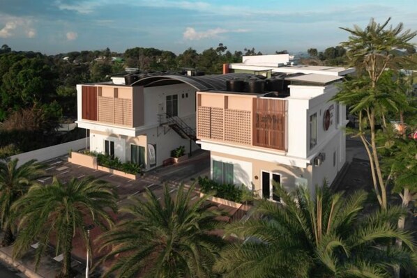 Un bâtiment moderne à deux étages, doté d’un toit plat, de grandes fenêtres et d’un balcon.