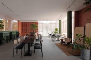Una sala de conferencias moderna con una mesa larga, sillas y una pared de acento verde.