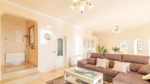 A living room with a brown sofa, a glass coffee table, and a white radiator. - Villa 'Macondo Altea Hills' with Sea View, Wi-Fi and Air Conditioning (Altea)