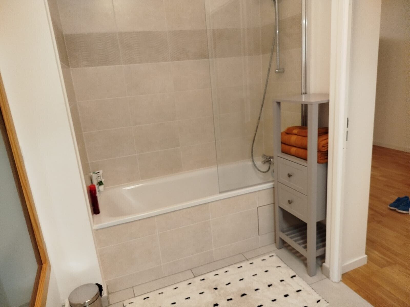 A bathroom with a bathtub, a shower, and a towel rack.