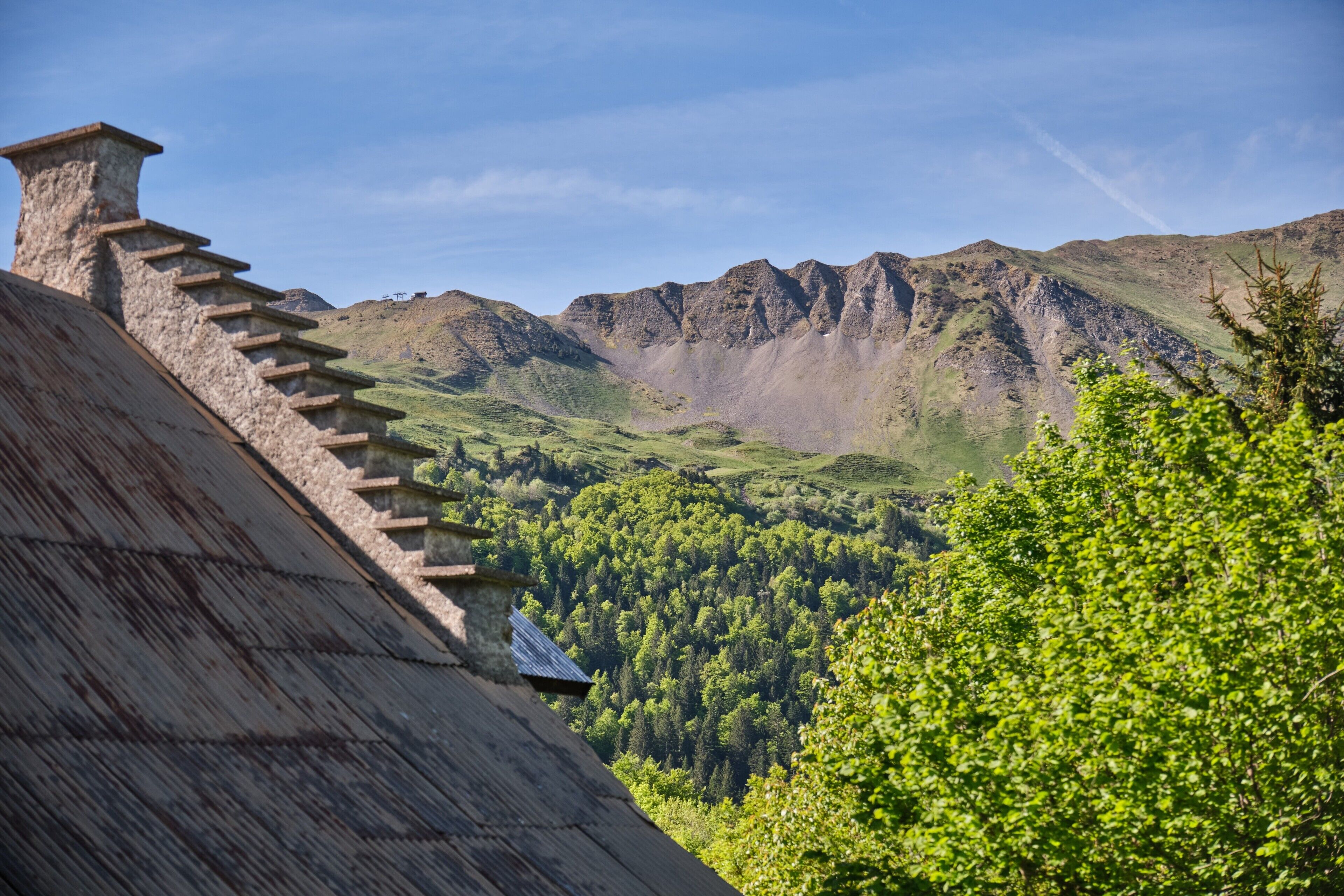 A mountain landscape with a wooden staircase and a building with a sloped roof.