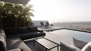 Ein stilvoller Außenbereich mit einer Couch, einem Couchtisch und zwei Lounge-Stühlen.